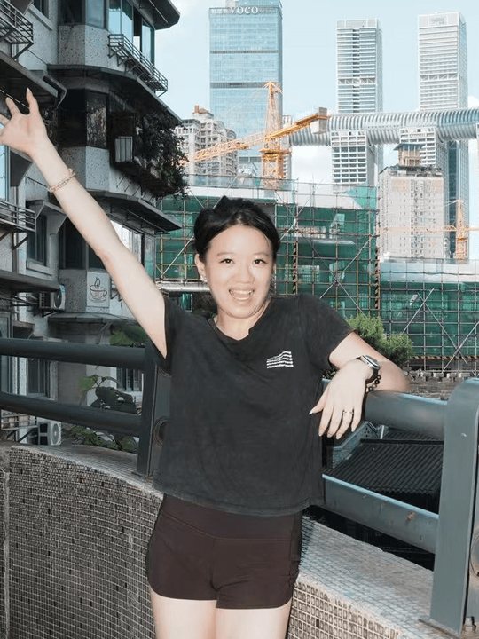 Rebecca waving in front of a city skyline